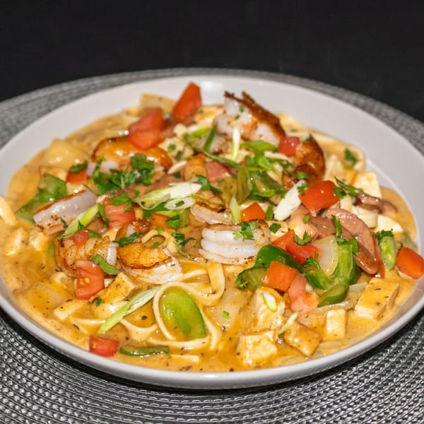 Southern shrimp and pasta dish with tomatoes, green peppers, and onions in a creamy sauce.