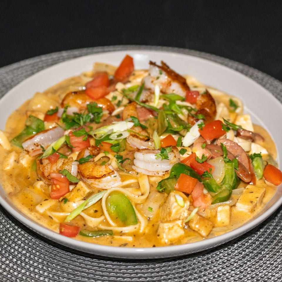 Southern shrimp and pasta dish with tomatoes, green peppers, and onions in a creamy sauce.