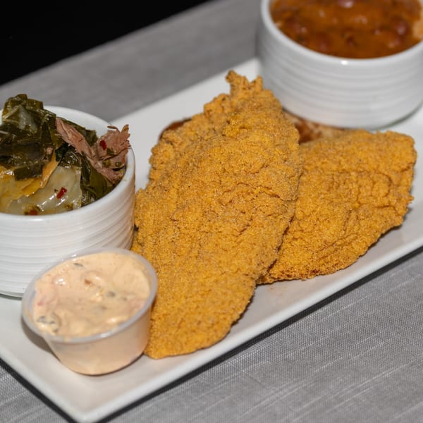 Southern fried catfish with collard greens, baked beans, and a side of tartar sauce.