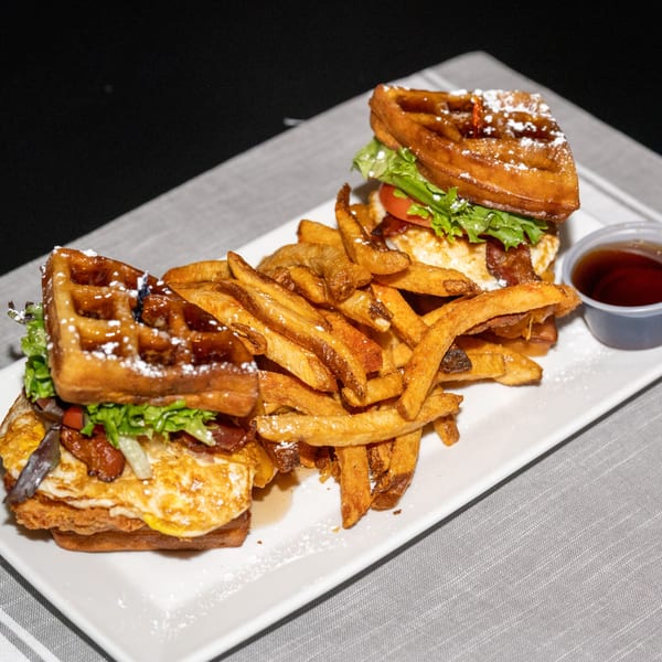 Two Ridiculous Eatz waffle sandwiches with fried chicken, bacon, egg, lettuce, and fries.